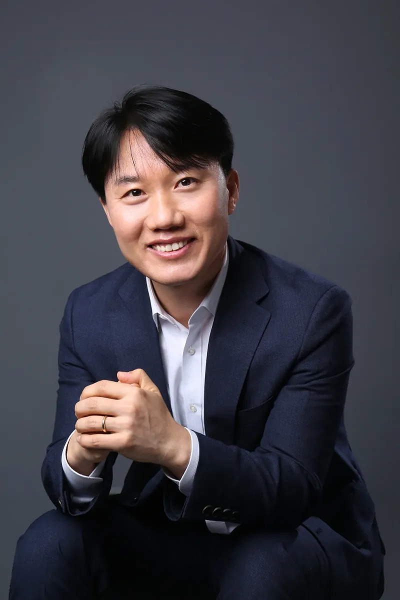 지병근 대표세무사가 양손을 모으고 앉아 미소 짓는 프로필 사진