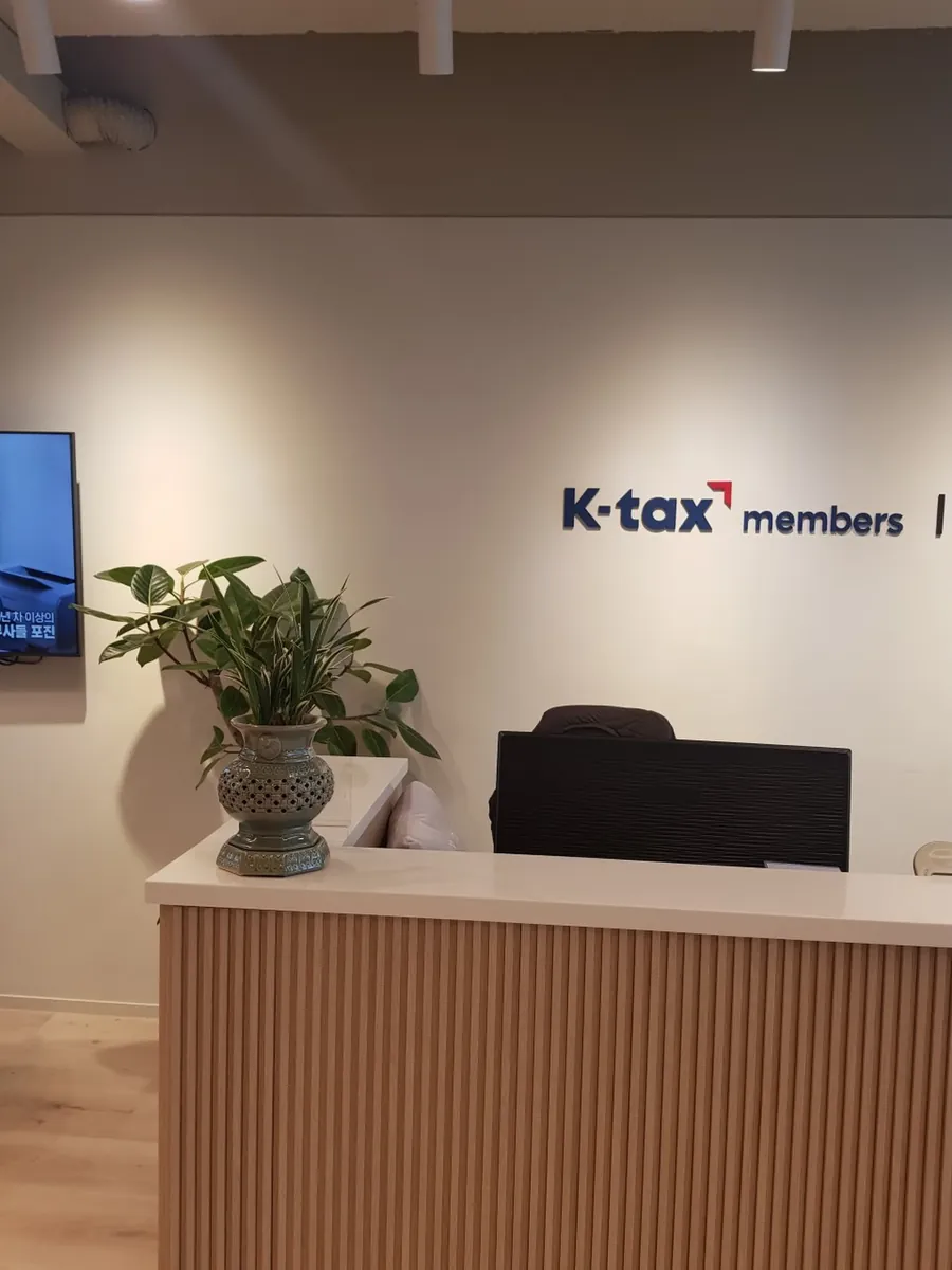 K-tax members 로고 벽면 앞 상담 접수 데스크